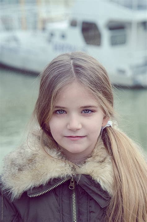 Portrait Of Blonde Cute Girl Age 8 Near The River By Stocksy