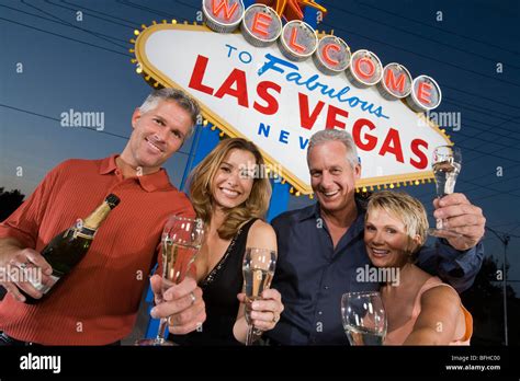 Two Women And Two Men Posing In Front Of Welcome To Las Vegas Sign