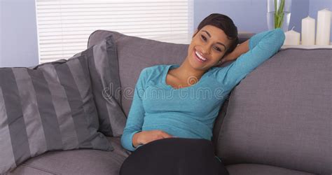 Mujer Negra Linda Que Descansa Sobre La Sonrisa Del Sofá Foto De