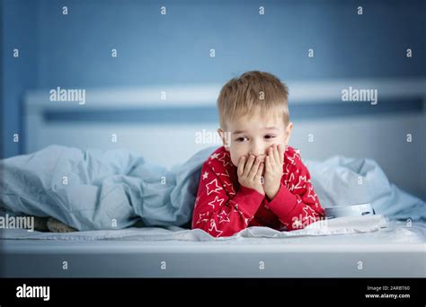 Sleepy Boy Lying In Bed With Blue Beddings Stock Photo Alamy