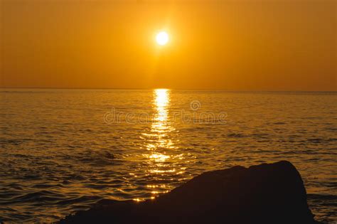 Amazing Tropical Orange Sunset Over Water With Rock