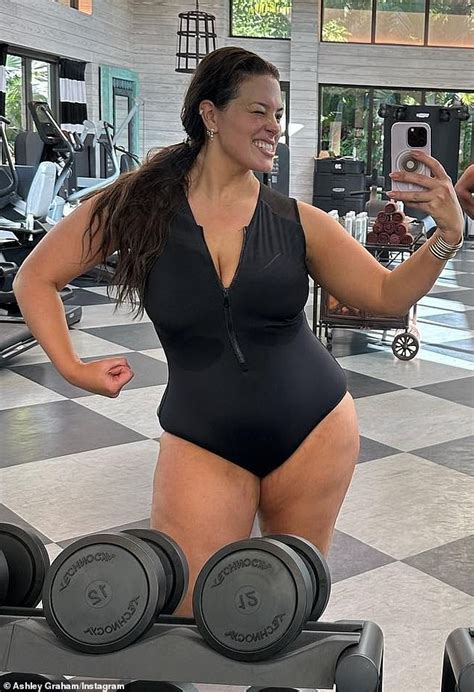ashley graham flaunts her ripped physique as she flexes in the mirror while working out