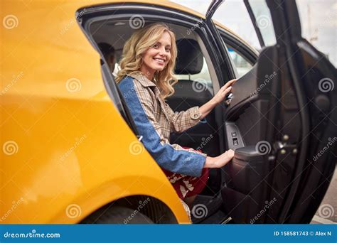 Image Of Happy Blonde Sitting In Back Seat Of Yellow Taxi With Open Door Stock Image Image Of