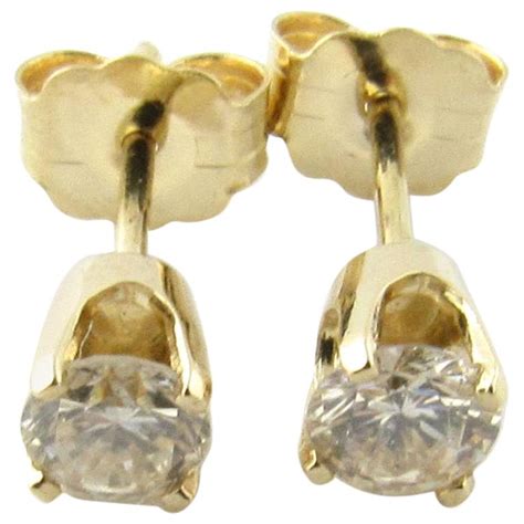 Totaling 1 ct., the two diamonds reflect their wearer's refined, sophisticated elegance. 14 Karat Yellow Gold Diamond Stud Earrings .40 Carat For Sale at 1stdibs