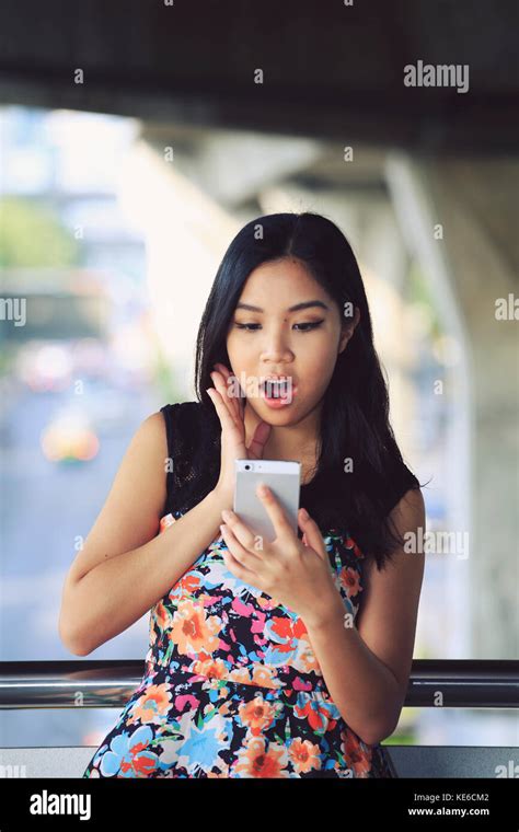 Young Woman Shocked At Text Message On Her Mobile Phone Stock Photo Alamy