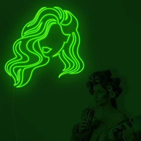 a woman with long hair holding a drink in front of a neon sign