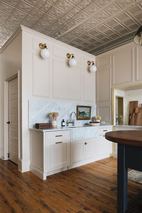 Use light paint colours in smaller rooms. Love this cream kitchen cabinet color and marble ...