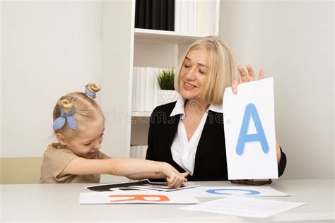 Female Teacher With Girl Patient Learning Pronunciation Stock Image