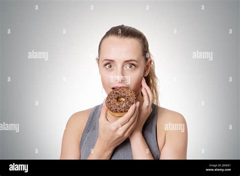 Fitness Woman Eating A Cheeky Donut Stock Photo Alamy