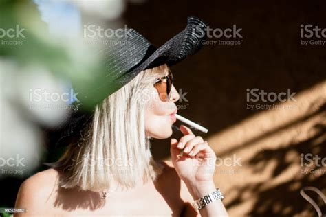 Beautyful Stylish Young Blonde Woman Smoking Cigarettes Outdoors In Han