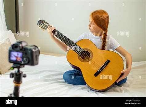 Portrait Of Sweet Child Girl Blogger Studying Chords In Acoustic Guitar