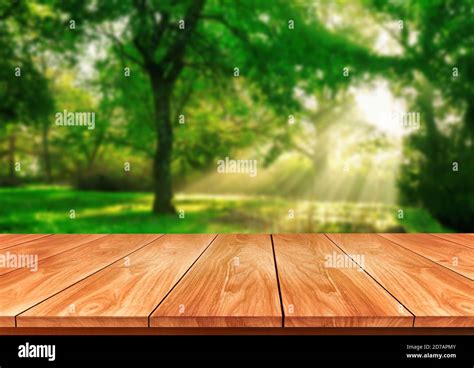 Brown Wood Table In Green Blur Nature Background Of Trees And Grass In