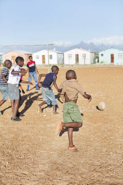 African Boys Playing Soccer Together In Dirt Field — Vertical Fun