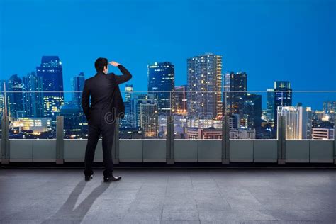 Portrait Of Asian Businessman Looking Out The City In The Balcony Stock