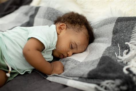 African American Baby Boy Sleeping On Side Lying In Bed Stock Image