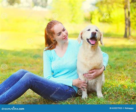 Happy Owner Woman And Golden Retriever Dog Sitting On Grass Stock Image