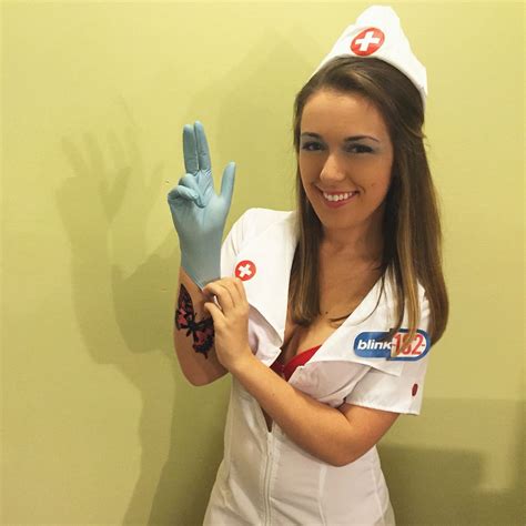 a woman dressed as nurse holding up two fingers