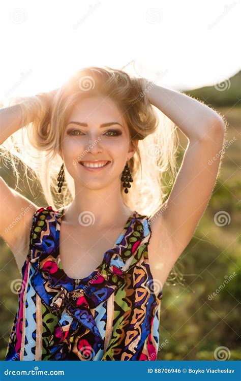 beautiful dreamy blonde girl with blue eyes in a light turquoise dress lying on the stones stock