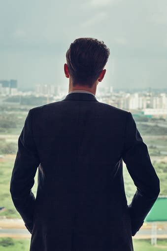Back View Of Businessman Standing By Window Stock Photo Download