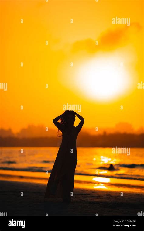 Silhouette Woman Standing On Beach During Sunset Stock Photo Alamy