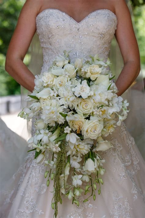 cascade bouquet with white orchids white peonies cream roses white stephanotis white tulips