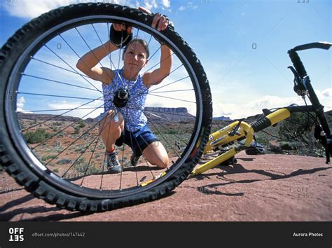 In order to learn how to repair a flat tire, one must learn the terminology and components involved. Woman fixing flat tire on her mountain bike while riding ...