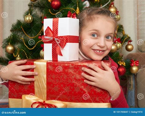 girl with t boxes near christmas tree happy holiday and winter celebration stock image