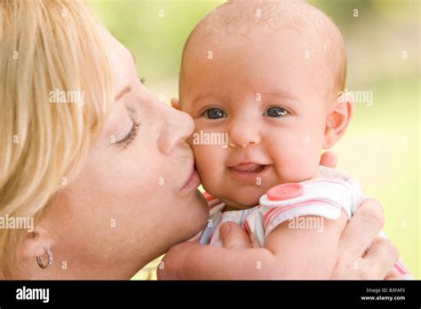 Mother Kissing Baby Outdoors Stock Photo Alamy