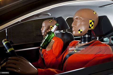 A Crash Test Dummy Drinking A Beer While Driving With A Crash Test
