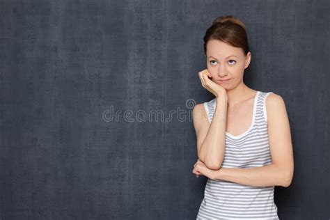 Portrait Of Thoughtful Tired Young Woman Propping Up Head With Hand