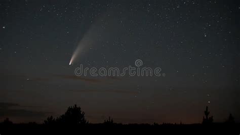 The Comet Moves Across The Night Sky Among The Stars Stock Photo