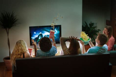 Group Of Friends Watching Halloween Scary Movie Together At Home Stock