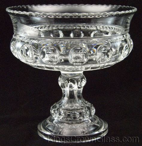 A Clear Glass Bowl With Ornate Designs On The Rim And Base Sitting On A Black Background