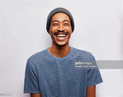 Laughing Young Man Standing Against A Gray Background High Res Stock