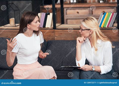 Side View Of Woman Gesturing By Hands And Talking To Female Counselor