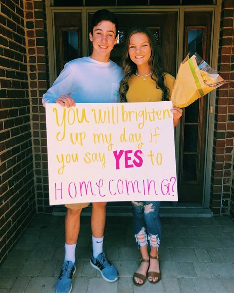 two people standing in front of a door holding a sign that says you will brighten up my day if