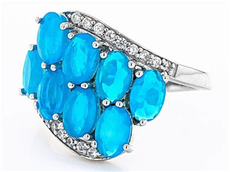 An Image Of A Ring With Blue Stones And Diamonds On The Sides Set In