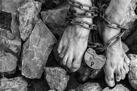 Chains With A Lock On The Legs Of A Slave Amidst Stones Chains At The