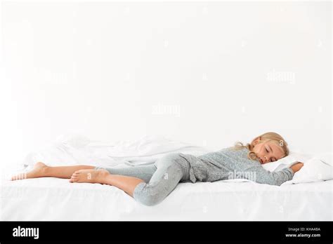 Full Length Portrait Of Sleeping Peaceful Girl In Gray Pajamas Lying In