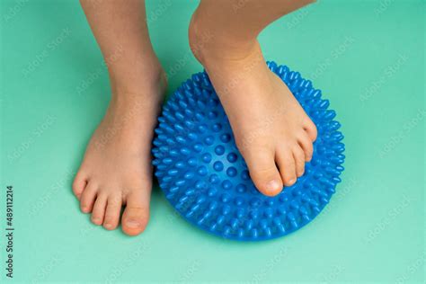 Childrens Feet With A Blue Balancer On A Light Green Background