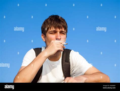 Sad Young Man Smoking Cigarette On The Sky Background Stock Photo Alamy