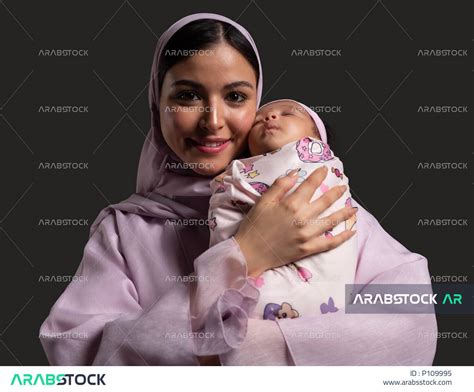 الاهتمام براحة وسلامة الرضيعة، بورتريه مقرب لأم عربية خليجية سعودية محجبة ترتدي العباءة الملونة
