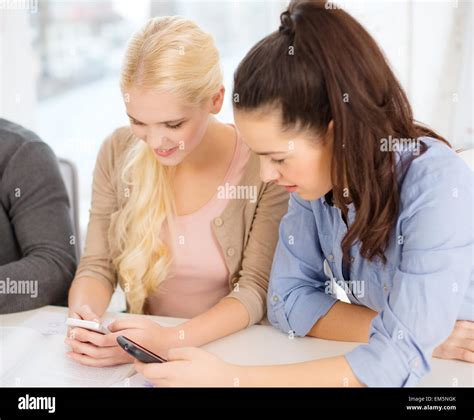 Two Teens With Smartphones At School Stock Photo Alamy