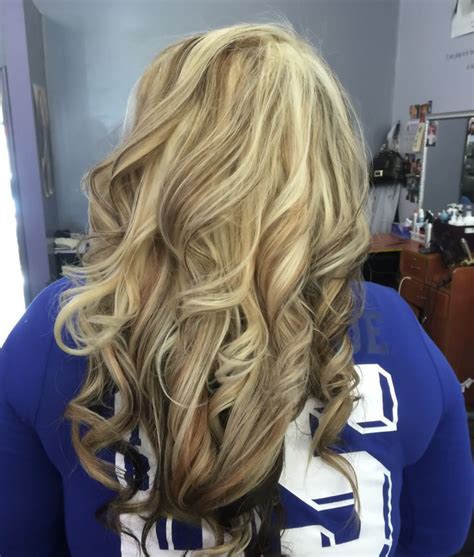 Light blonde shade running through the long and curly strands at even partitions produces a fascinating hairstyle. Golden blonde hair, heavy light blonde highlight, with ...