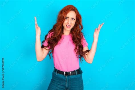 Crazy Outraged Young Redhead Woman Wearing Pink T Shirt Over Blue