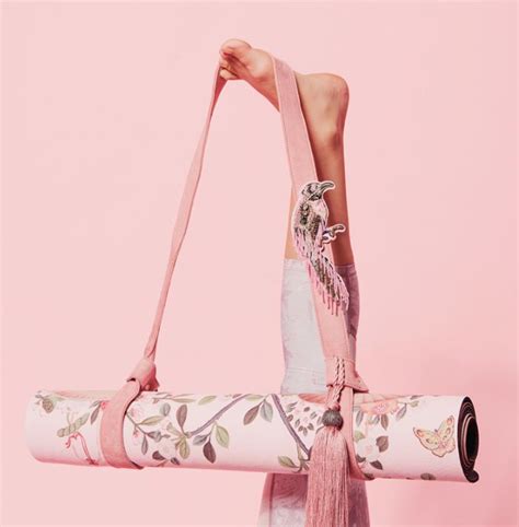 A Woman Holding A Pink Yoga Mat With Flowers On It