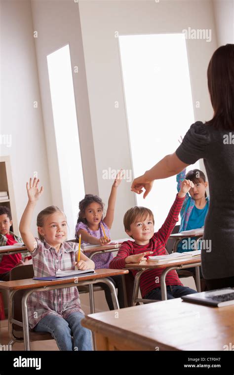 Usa California Los Angeles Pupils In Classroom Raising Hands Stock