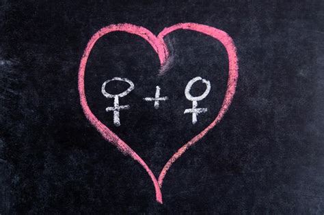 premium photo heart shape with gender symbols drawing on blackboard