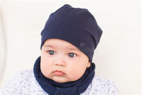 Close Up Portrait Of Cute Baby Boy Wearing Blue Hat Stock Photo