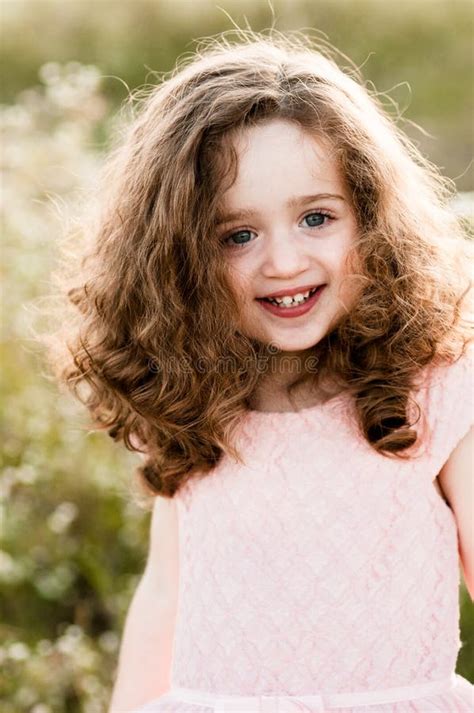 Portrait Of A Smiling Charming Little Girl With Curly Hair Stock Image